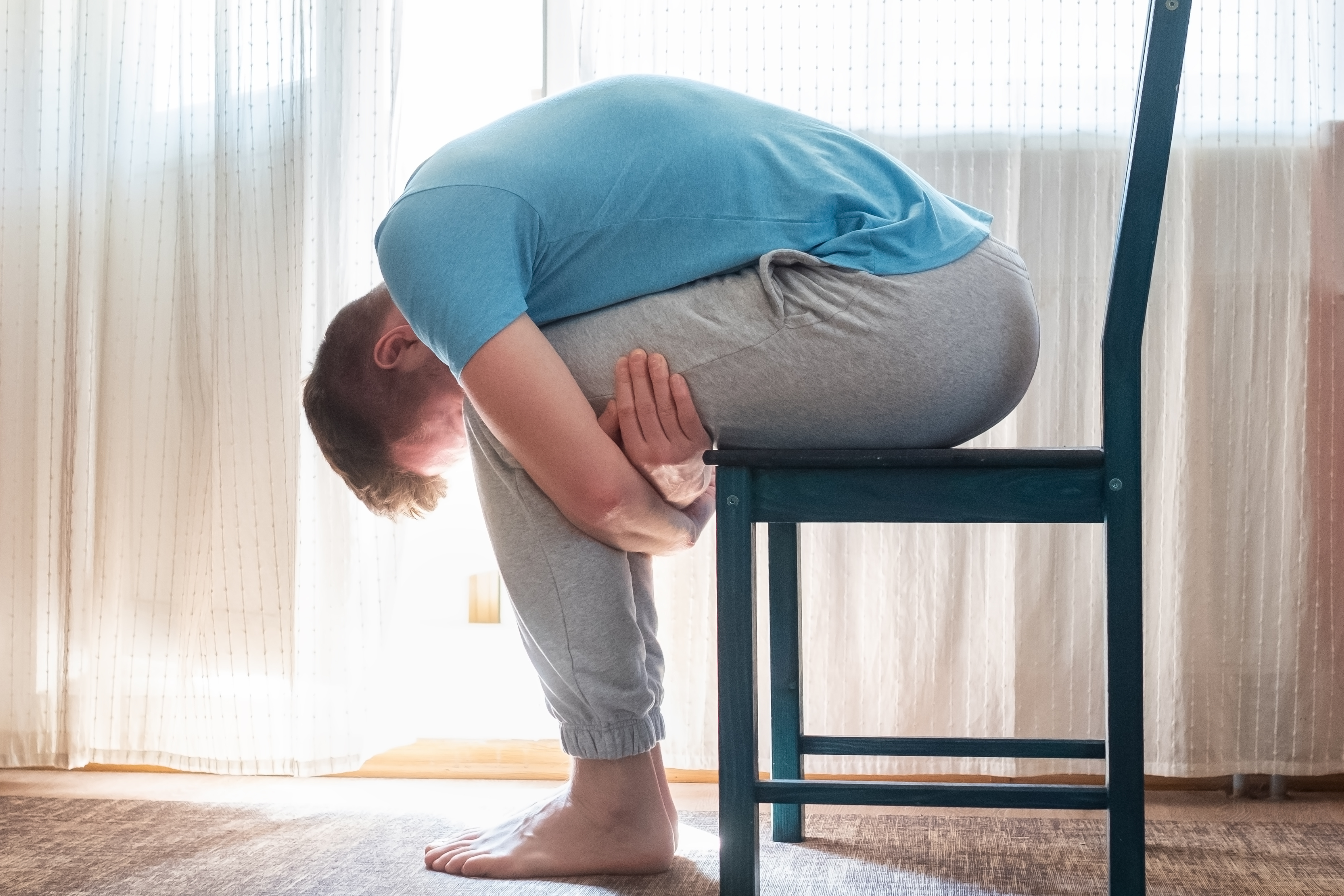 Image of male stretching back while seated